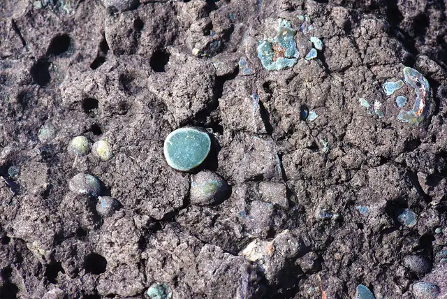 Small thomsonite eyes weathering out of basalt (locality not given; not a Michigan specimen)